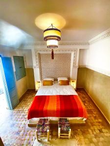 a bedroom with a large bed with a red blanket at Riad Magnolia & SPA in Marrakech