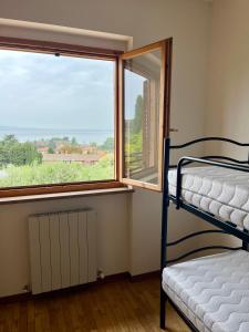een slaapkamer met een stapelbed en een raam bij La Casa Sul Lago in Passignano sul Trasimeno