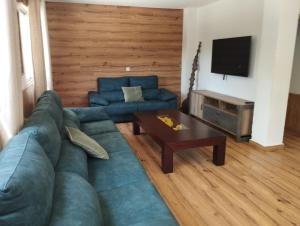 sala de estar con sofá azul y mesa en CASA RURAL HUERTA DEL MEDIO, en Granada