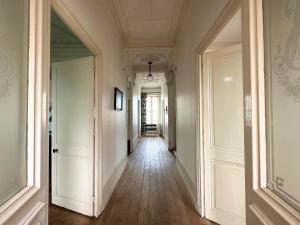 an empty corridor of a building with wood floors and ceilings at Villa RENNAISSANCE - Proche Mer - Parking - Ménage & Linge inclus in La Rochelle +19 photos
