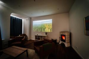ein Wohnzimmer mit einem Kamin und einem Wandgemälde in der Unterkunft Villa Levin: 120m², bis 8 Pers, free Wifi & parken 