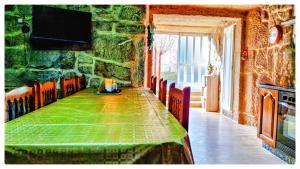 a dining room with a green table and chairs at Casa Carmen con finca y piscina privada in Cea