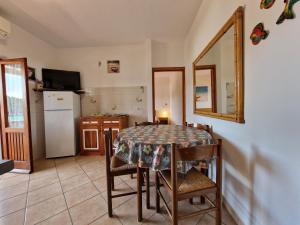 een keuken met een tafel en stoelen en een koelkast bij Appartamenti Fetovaia Lavanda in Fetovaia