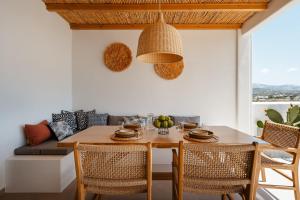 Un comedor con una mesa y sillas y un sofá. en C and G VILLAS, en Agia Anna de Naxos