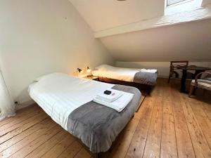 a room with two beds and a table and a window at Villa RENNAISSANCE - Proche Mer - Parking - Ménage & Linge inclus in La Rochelle