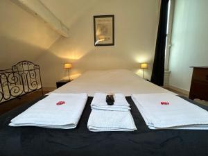 a bedroom with two white towels on a bed at Villa RENNAISSANCE - Proche Mer - Parking - Ménage & Linge inclus in La Rochelle