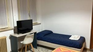 a small bedroom with a bed and a desk with a tv at La voglia in Villanova sullʼArda