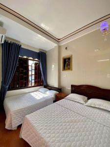 sypialnia z 2 łóżkami i oknem w obiekcie Nhà Nghỉ Thiên Tân 2 w mieście Quang Ngai
