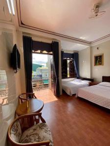 Habitación de hotel con 2 camas y balcón en Nhà Nghỉ Thiên Tân 2 en Quang Ngai