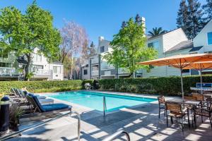 a swimming pool with chairs and an umbrella at Santa Clara 1BR w Spa Pool AC in downtown SFO-847 in Santa Clara