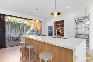 una cocina con una encimera grande con taburetes. en Elegant 3BR House San Francisco en San Francisco