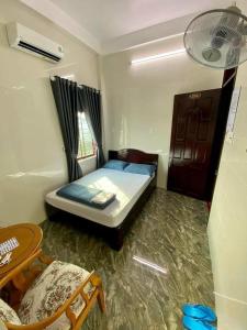 1 dormitorio pequeño con 1 cama y 1 silla en Nhà Nghỉ Thiên Tân 2 en Quang Ngai