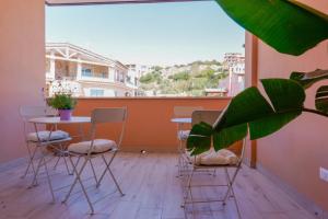 un balcón con mesa, sillas y una planta en Domo Green House en Villasimius
