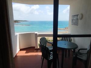 balcone con tavolo, sedie e vista sull'oceano di Playa Las Fuentes ad Alcossebre
