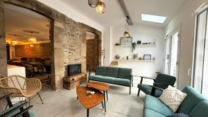 ein Wohnzimmer mit einem Sofa, Stühlen und einem Kamin in der Unterkunft Maison LAURENTZENIA in Saint-Jean-Pied-de-Port