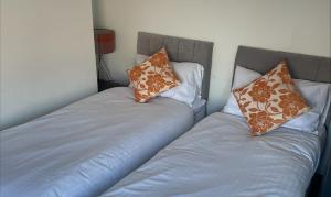 dos camas sentadas una al lado de la otra en una habitación en Quirky and Cosy Self Contained Flat, Ferryhill Near Durham en Ferryhill