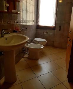ein Bad mit einem Waschbecken und einem WC in der Unterkunft Il Fenicottero Rosa Casa Sanzio in Quartu SantʼElena