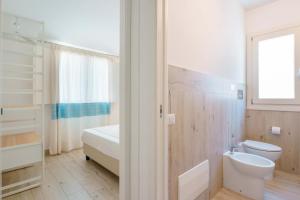 bagno bianco con servizi igienici e lavandino di Domo Green House a Villasimius