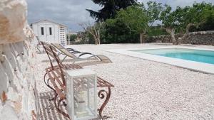 un par de sillas sentadas junto a una piscina en Casa Vacanze Villa Greca, en Martina Franca