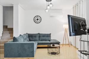 a living room with a blue couch and a tv at Sea La Vie in Nikiana