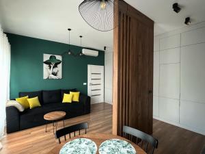 a living room with a black couch and a table at Apartament Serce Miasta in Wrocław