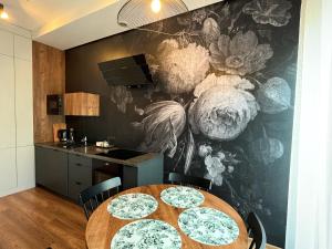 a dining room with a table and a kitchen at Apartament Serce Miasta in Wrocław