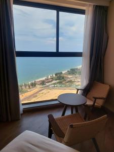 a room with a table and chairs and a large window at M2007 Apec mandela Mũi né in Ấp Long Sơn