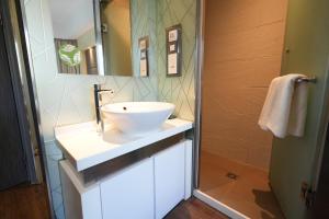 een badkamer met een witte wastafel en een spiegel bij 盛世酒店 Epoch Hotel in Hong Kong