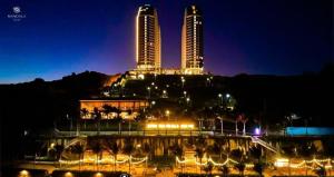 a view of two tall buildings at night at M2007 Apec mandela Mũi né in Ấp Long Sơn