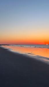 a view of a beach at sunset with the ocean at Oceanview Romantic Escape-King Suite, Balcony, Pool & Bar! in Hilton Head Island