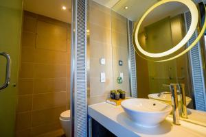 a bathroom with a sink and a mirror at Epoch Hotel in Hong Kong