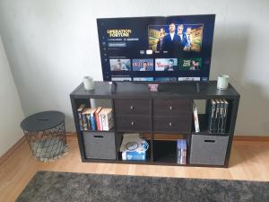a black entertainment center with a flat screen tv on top at Ferienwohnung ErzHome in Marienberg