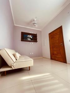 a living room with a couch and a tv on the wall at Residencial Floreana Apto Estrela in Salinópolis