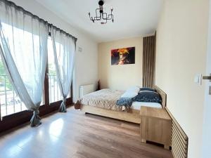 a bedroom with a bed and a chandelier at Apartament Serce Miasta in Wrocław