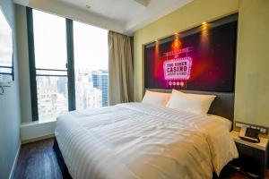 a bedroom with a large bed with a sign on the wall at Epoch Hotel in Hong Kong