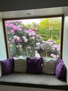 um sofá em frente a uma janela com flores cor-de-rosa em 7 Bedroom Secluded Villa close to Prague em Ricany