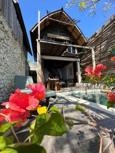 um edifício com piscina e flores vermelhas no primeiro plano em Divinity Villas - Uluwatu, Bali em Uluwatu