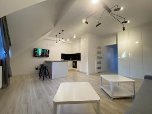a white living room with a table and a couch at Nata&K in Polkowice