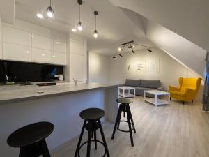 a kitchen and living room with two stools and a counter at Nata&K in Polkowice