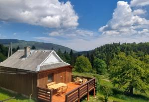 a cabin in the middle of a field with a deck at Будиночок для щастя in Yaremche