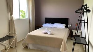 a bedroom with a bed with two towels on it at Residencial Floreana Apto Estrela in Salinópolis +11 photos