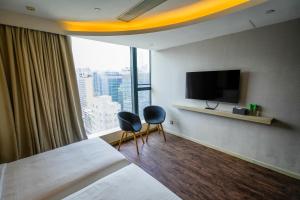 une chambre d'hôtel avec deux chaises et une grande fenêtre dans l'établissement 盛世酒店 Epoch Hotel, à Hong Kong