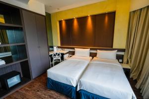 a hotel room with two beds and a window at Epoch Hotel in Hong Kong