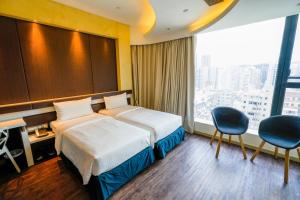 a hotel room with a bed and a large window at Epoch Hotel in Hong Kong