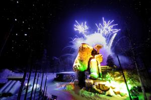 a statue of a bear with fireworks in the background at Hunderfossen Snow Hotel in Hafjell