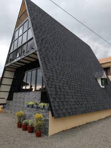 Eden Cottage في كوتشي: سقف أسود على مبنى به نباتات في أصص