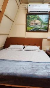 a bedroom with a large bed with a window at Eden Cottage in Cochin