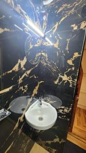 a bathroom with a sink and a marble wall at Eden Cottage in Cochin +19 photos