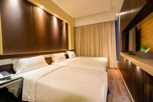 a hotel room with two beds and a television at Epoch Hotel in Hong Kong