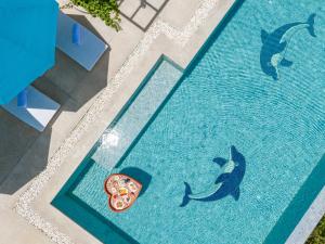 an overhead view of a pool with a pizza and a dolphin at 宛如梦境 一线海景6卧室别墅 超大私人泳池 免费早餐接机 私人影院健身房 in Phuket Town